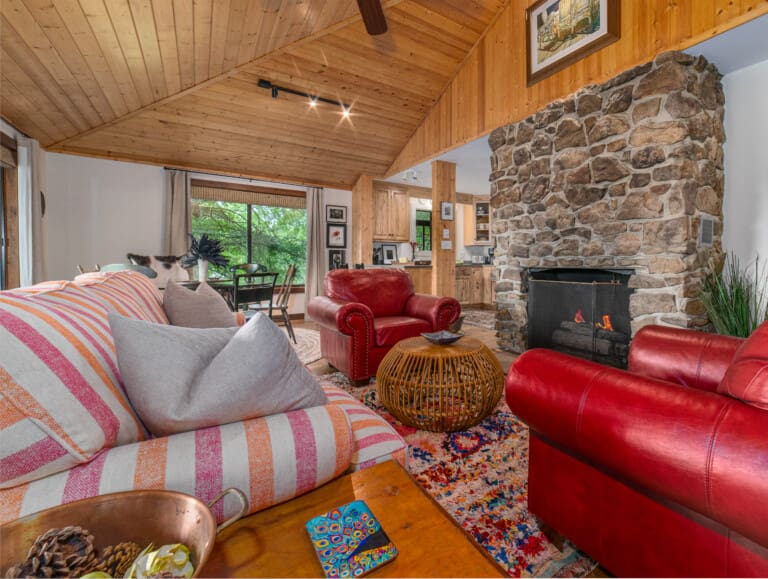 Relax in the open living area, complete with a cozy stone fireplace featuring gas logs. Enjoy meals in the dining space or at the kitchen bar with two seats, and unwind in the game area. The TV is equipped with streaming services.